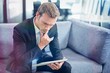 © vectorfusionart - Thoughtful businessman looking at digital tablet
