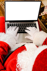 Wall Mural - Santa Claus working with modern laptop on his lap, view from above