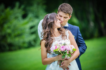 Beautiful young bride and groom in park