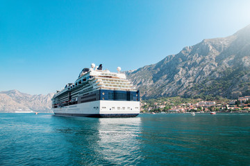 Wall Mural - Cruise liner ship swimming at blue adriatic sea, mountains landscape