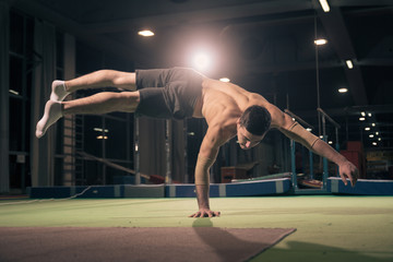 Young man gymnast, one hand cartwheel