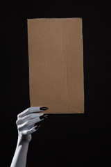 Poster - White ghost hand with black nails holding blank cardboard