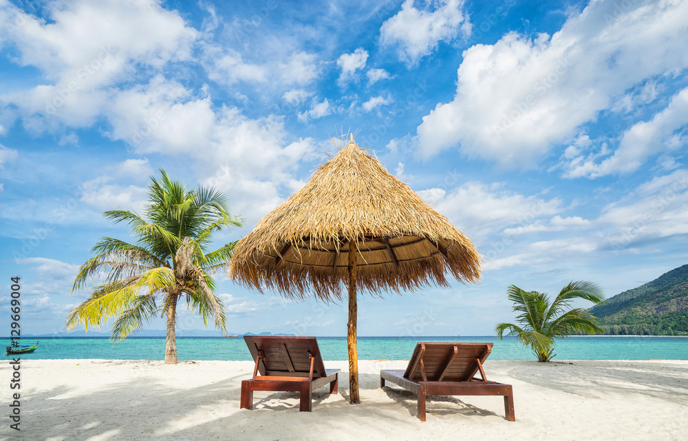 Vacation in tropical countries. Beach chairs, umbrella and palms on the beach. - obrazy, fototapety, plakaty 