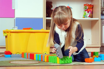 Wall Mural - Three-year girl playing and learning in preschool