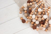 Knitted Beads Necklace On White Wooden Backroung