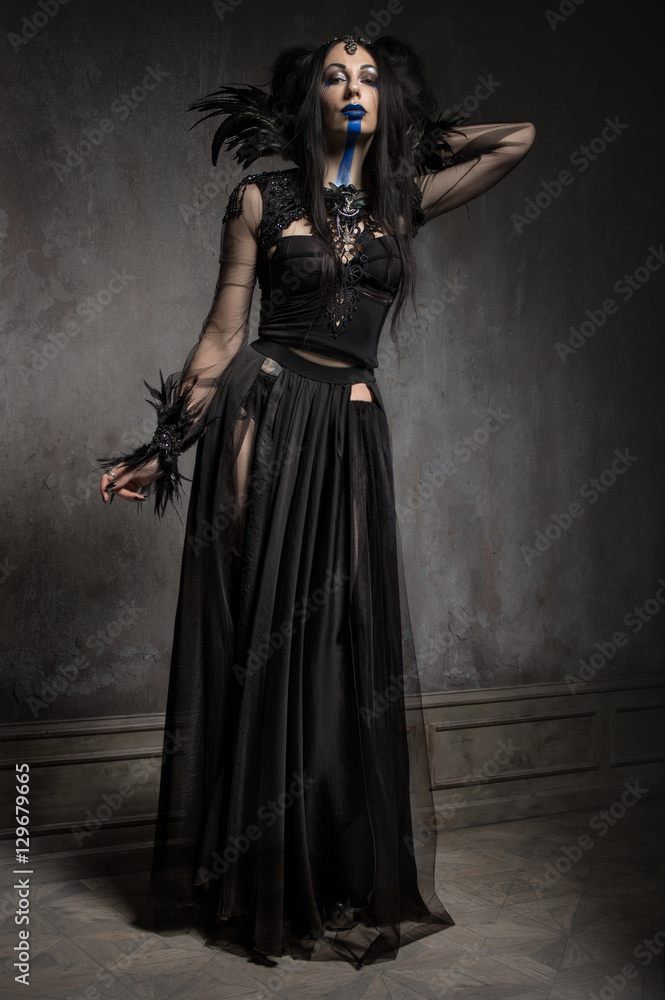 Young woman in black fantasy costume with feathers on dark background Stock  Photo | Adobe Stock