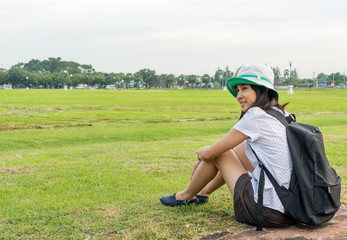 Young travel girl sitting at nature park, Hipster woman with bac