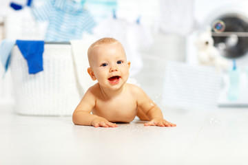 Wall Mural - fun happy baby boy  to wash clothes and laughs in laundry