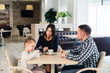 © romankosolapov - Family sitting together at table in a restaurant