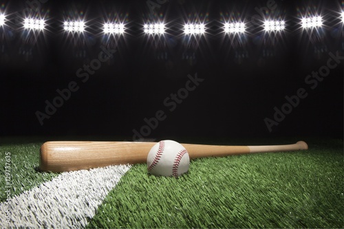 Plakat Baseball i nietoperz przy nocą pod stadium zaświecamy na trawy polu