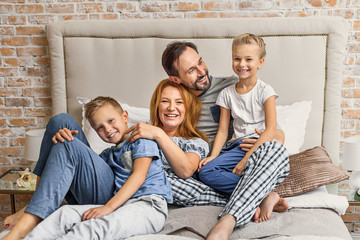 Wall Mural - Happy family lying down on bed at home