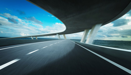 Highway and bridge overpass motion blur with seacape background