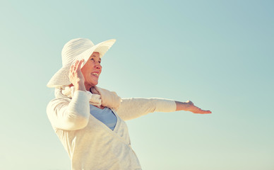 Poster - happy senior woman in sun hat over blue sky