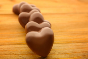 Wall Mural - Chocolate hearts on wooden background