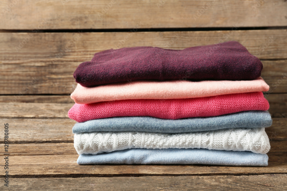 Stack of folded clothes on wooden background