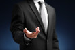 © Africa Studio - Businessman with empty hand on dark background
