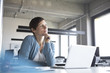 © Westend61 - Businesswoman in office with laptop thinking