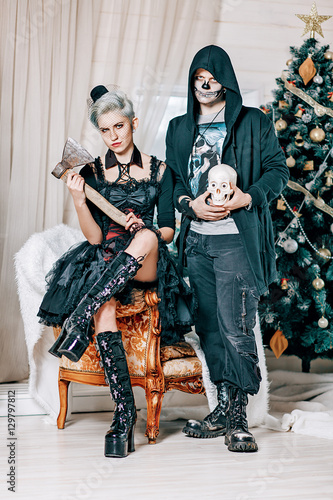 Young gothic couple posing near a Christmas tree Poster