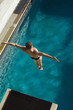 © MDBPIXS - High angle view of a male swimmer jumping from springboard into the pool