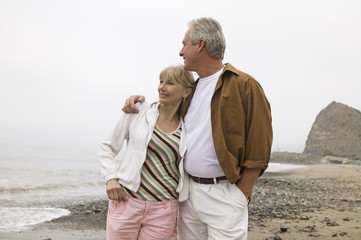 Wall Mural - Loving middle aged man embracing woman on beach