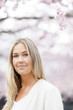 © FOLIO - Sweden, Stockholm, Kungstradgarden, Smiling young woman under blooming tree