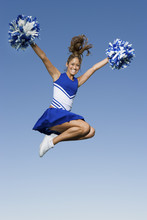 Full Length Of A Young Cheerleader Jumping Against Clear Sky