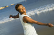 © moodboard - Portrait of cheerful African American woman enjoying vacation on beach