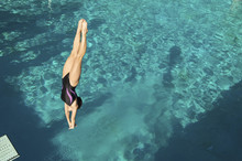Active Female Diver Diving Upside Down Into The Swimming Pool