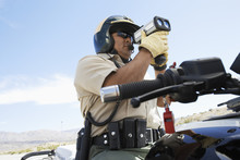 Low Angle View Of A Police Officer Looking Through Radar Gun