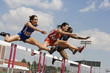 © moodboard - Multiracial female athletes clearing hurdles in race