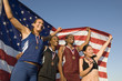 © moodboard - Low angle view of happy female athletes holding American flag against clear blue sky