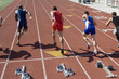 © MDBPIXS - Multiethnic male athletes running from starting block on track