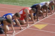© MDBPIXS - Group of multiethnic male runners at starting blocks in racetrack