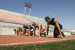 © MDBPIXS - Group of multiethnic male runners at starting blocks in racetrack