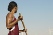 © moodboard - African American female pole vaulter holding pole against clear sky
