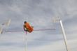 © MDBPIXS - Low angle view of male pole vaulter clearing bar against cloudy sky