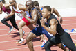 Side view of multiethnic male athletics sprinting on running track