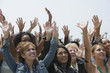 © moodboard - Group of multiethnic women raising hands against clear sky