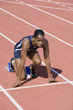 © moodboard - Full length of African American female athlete at starting line on running track