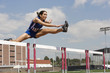 © moodboard - Determined female athlete jumping over a hurdles