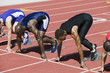 © moodboard - Multiethnic male athletes at starting line in track race