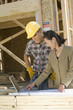 © moodboard - Architect and worker looking at plan on laptop at construction site