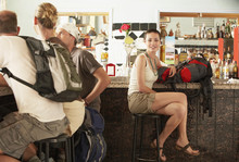Happy Hikers With Backpacks Sitting In Bar