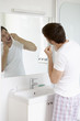 © MDBPIXS - Young man flossing his teeth in front of mirror