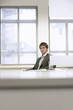 © moodboard - Portrait of a serious businessman sitting at desk in office