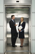 © MDBPIXS - Happy business colleagues communicating in elevator