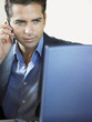© MDBPIXS - Young businessman on call while using laptop