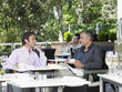 © MDBPIXS - Happy businessmen conversing at outdoor cafe