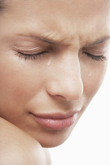 Wall Mural - Detailed image of sad young woman with tears isolated on white background