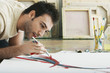 © moodboard - Closeup of a young man painting on canvas on studio floor